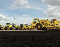 arieal view of excavators and loaders in yard with shop